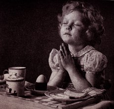 Photograph of a young girl giving thanks to God for her breakfaSt Dated 20th Century