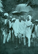 Mahatma Gandhi walks to a protest in the monsoon rain 1935