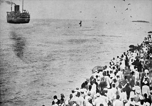 Crowds wave farewell to Mahatma Gandhi and his ship the SS Rajputna as he sails to join the Second Round Table Conference on India 1931; with him are Sarojini Naidu, Prabhashankar Pattani, A