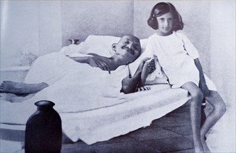 Mahatma Gandhi during a hunger strike is accompanied by Indira