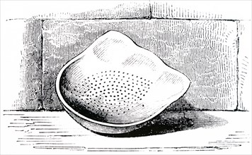 A stoneware cream skimmer