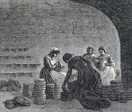 Women scraping cheese in the caves at Roquefort in France