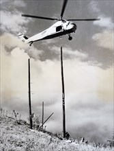 Photograph of a helicopter being used to aid the construction of a building