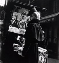 Photograph of French fashion models posing by a news magazine stand in Paris during the German occupation 1941