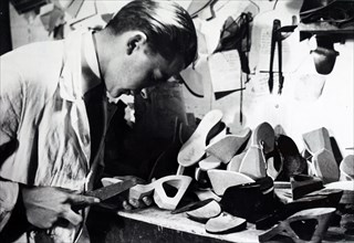 Photograph of a cobbler preparing heels for women's shoes during the German occupation of France 1941