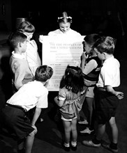 Photograph taken of children of the United Nations International Nursery School looking at a poster of the Universal Declaration of Human Rights