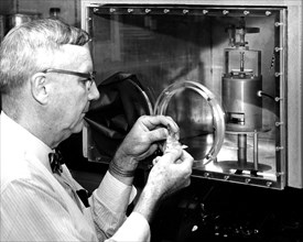 Photograph of a physicist monitoring a complex experiment using a closed respirometer