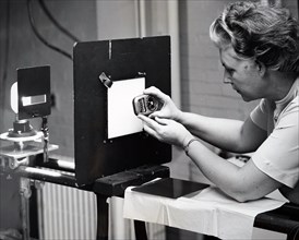 Photograph showing a female scientist measuring light with a light meter