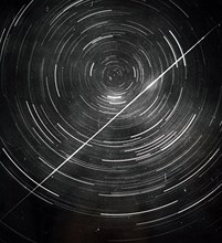 Long exposure photograph of circumpolar stars with a meteor trail