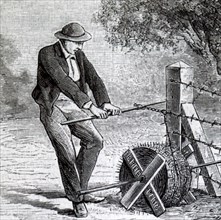 A farmer pulling barbed wire taut before fixing to a fence poSt Dated 19th Century