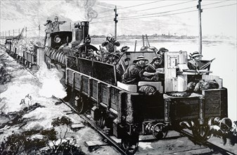 The rear of an armoured train with a Nordenfeldt gun mounted in a wagon in front of the engine