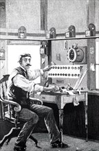 A train dispatcher using a Morse key to send a message down the line on the railway telegraph system