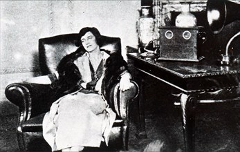 Photograph of a woman sat listening to a radio broadcaSt Dated 20th century