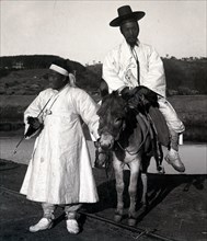 Korean official on a donkey led by a servant. Joseon Era. Circa 1900