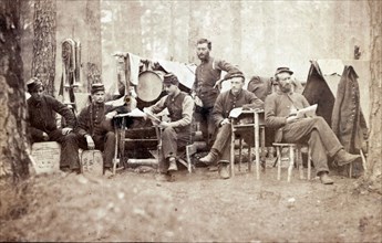 Six Union musicians of the 4th Vermont Infantry Regiment relaxing at camp in a pine forest in Virginia