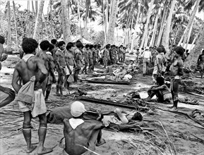 Wounded American soldiers of the 32nd Division are carried to the rear by Papua New Guinea natives during World War II