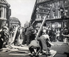 Parisians taking down German signs in Paris after the end of World War II