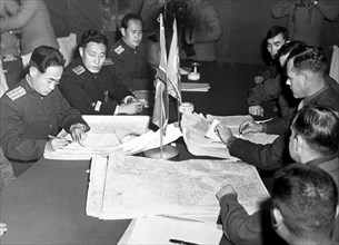 Col. James Murray, Jr., USMC, and Col. Chang Chun San, of the North Korean Communist Army, initial maps showing the north and south boundaries of the demarcation zone, during the Panmunjom cease fire ...