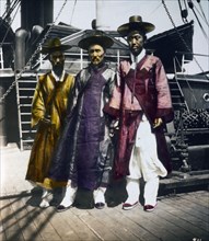 Korean business traders on board a ship on the Korean coast. Circa 1895