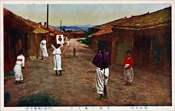 Korean children playing in a street with a kite. 1890