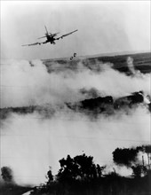 Two bombs tumble from a Vietnamese Air Force A-1E Skyraider over a burning Viet Cong hideout near Cantho, South Vietnam