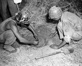 South Korean soldiers of the 1st Division, I Corps, prepare and lay an anti-tank mine during the Korean conflict