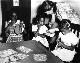 African-American schoolgirls learning to sew at school