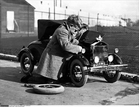 Young boy and model car, 1929