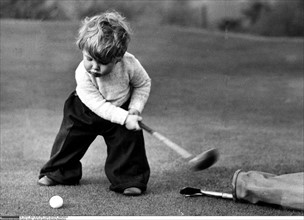 Young boy playing golf, 1951