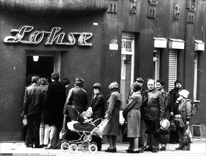 People waiting in line in front of a shop, GDR