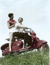 Young couple sitting on a motor scooter, 1954