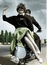 Young couple sitting on a motor scooter