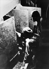 Howard Carter examines the tomb of Tutankhamun, 1923
