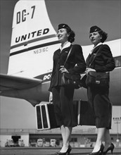 Stewardessen mit Gepaeck vor einem Flugzeug
