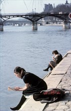Parisiens assis au bord de la Seine