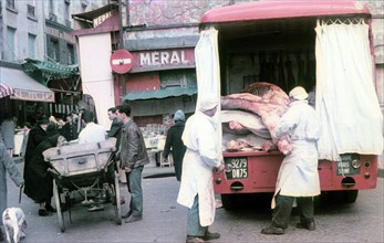 Butchers unload meat from a truck and deliver it to the covered markets in Paris