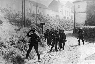 German troops watching the street of a Belgian village
