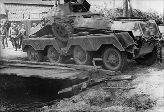A heavy German armoured reconnaissance vehicle crossing a creek over a makeshift bridge