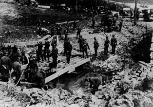 Invasion of the Netherlands: German engineer troops building a makeshift bridge over a small river
