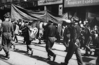 Demonstranten tragen Fahnen mit Hammer und Sichel