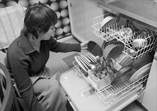 Jeune femme remplissant son lave-vaisselle