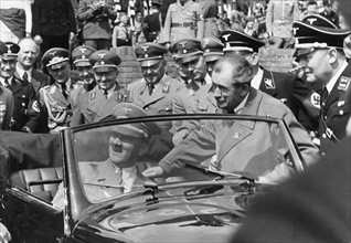 Hitler besichtigt einen Volkswagen, rechts daneben Dr. Ferdinand Porsche