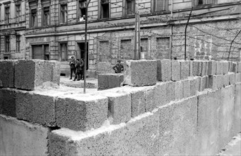 Germany Berlin - building of the wall; GDR border guiard behind the barb wire and the wall - 1961