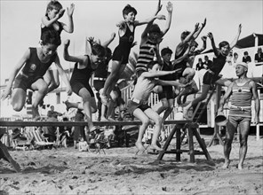 Young bathers jump over hurdles on Cannes beach
