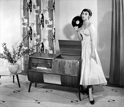 Woman in front of a record player in the living room