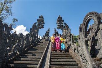 Young Balinese women descend stairs