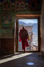 A monk going through a door at Thiksey Monastery
