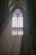 Rays of light fall through a coloured church window