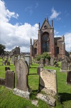 Old gravestones on cemetery and Romanesque-Norman cathedral St. Magnus