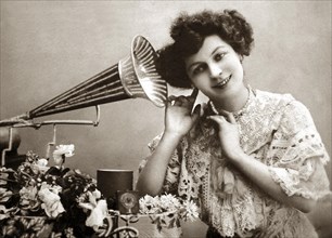 Woman listening to music with gramophone